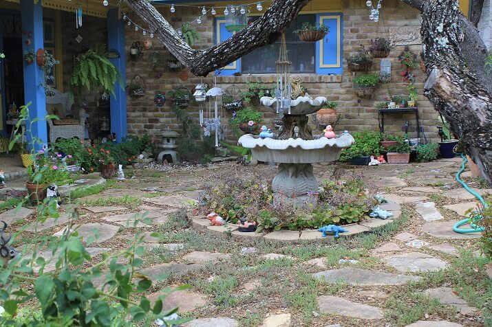 backyard stone area full of personality, fountain and plants