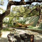 Shady patio with hammock and table area.