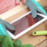 Woman's hands potting some plants ( with tablet pc)