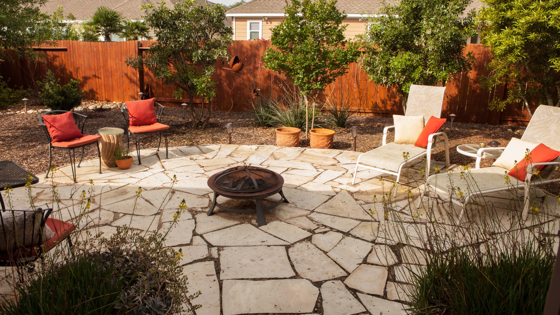 Flagstone patio with firebowl expands backyard living space.