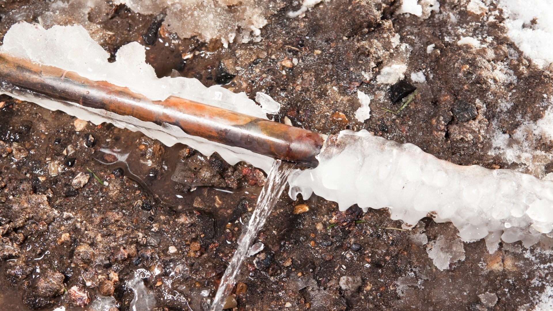 Leaking copper pipe covered in ice.