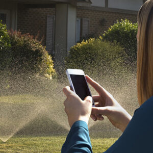Woman using phone to control sprinkler system