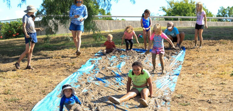 Image showing children and parents playing with mud.