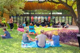 Picnicking visitors enjoying music on the concert lawn at San Antonio Botanical Gardens