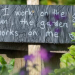 Event graphic for the GVST Gardening Essentials workshop, with a sign reading "I work on the garden, the garden works on me"