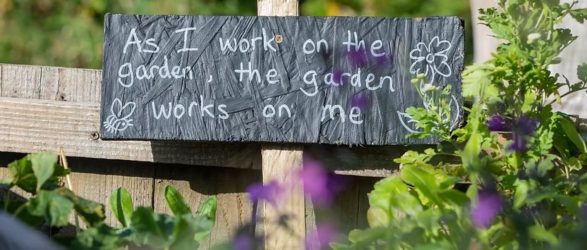 Event graphic for the GVST Gardening Essentials workshop, with a sign reading "I work on the garden, the garden works on me"